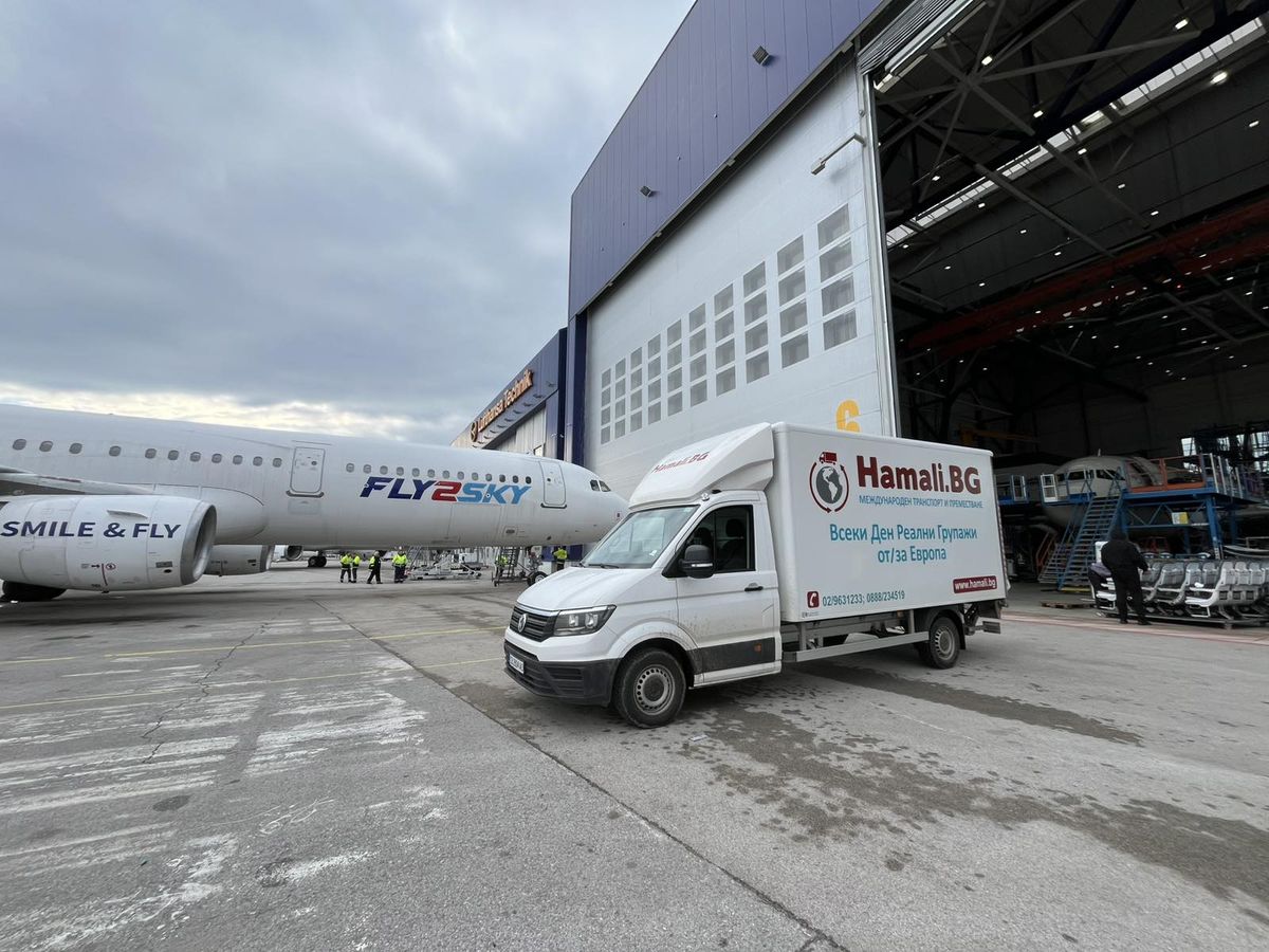 A Hamali.BG truck on the apron beside an aircraft at the airport